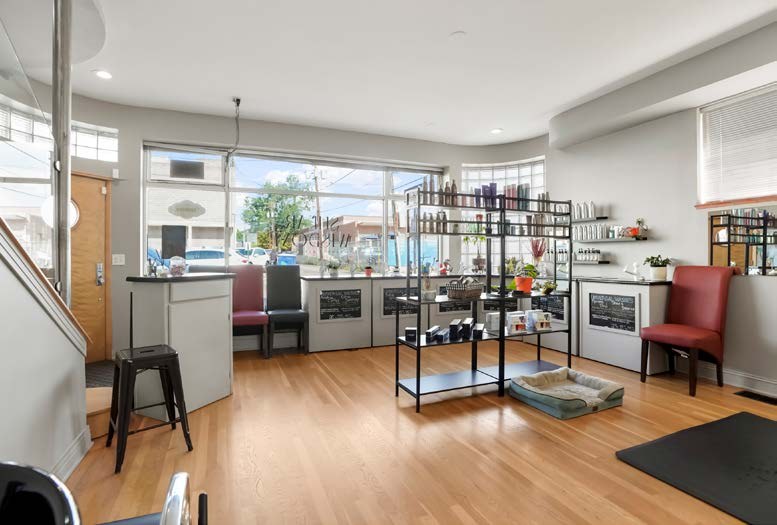 Ground floor room with wood floors and a wall of street-facing windows